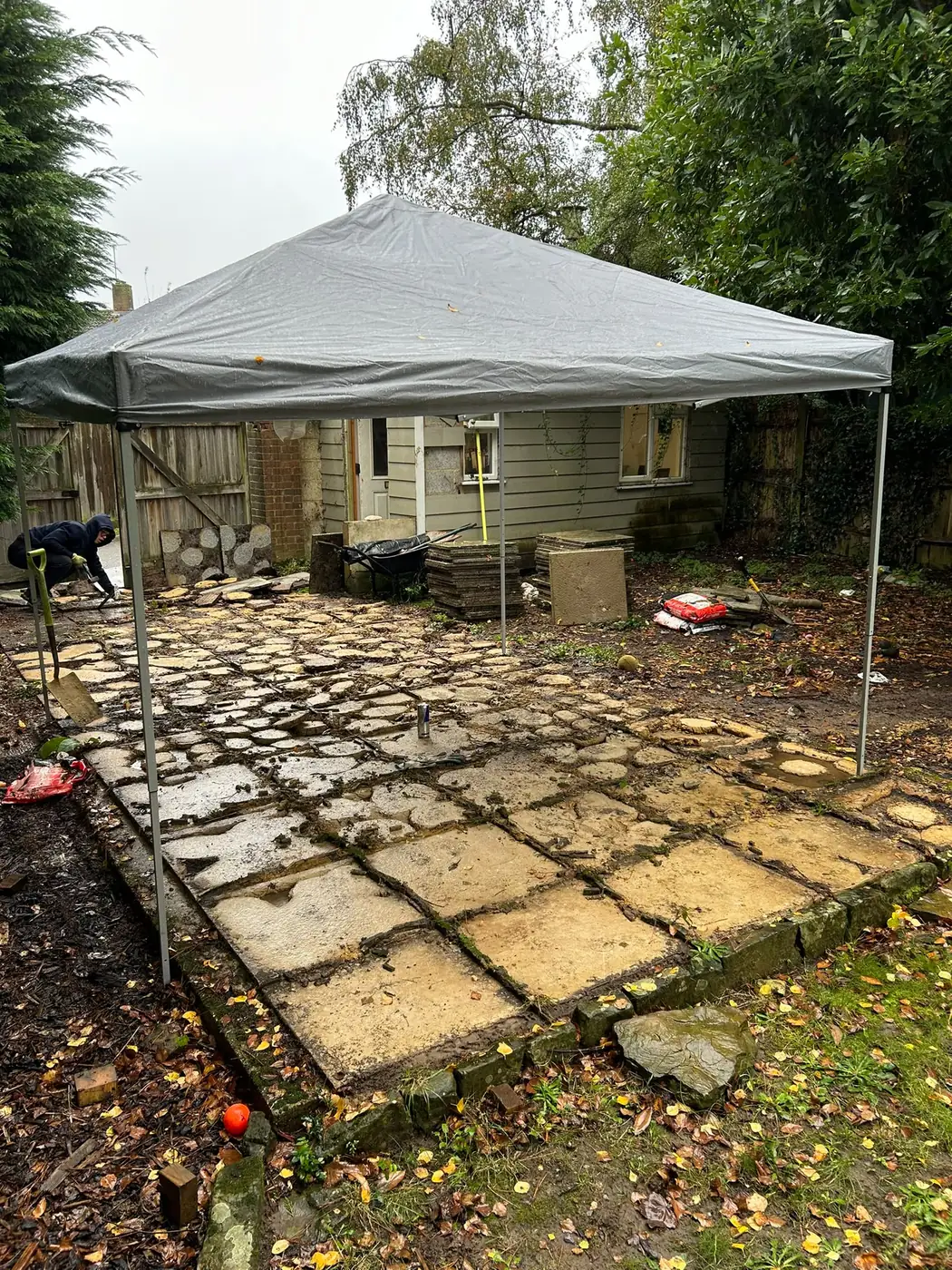 Worn paving beside the garden studio before replacement