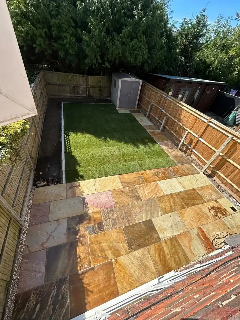 New lawn meeting a sandstone patio