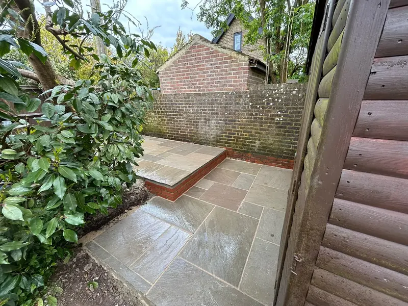 Sandstone patio with a raised brick step